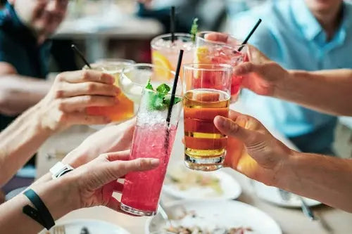 people toasting with beverages over a table