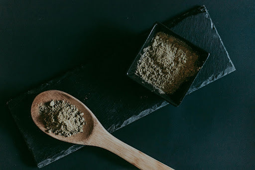 kratom powder in wooden spoon
