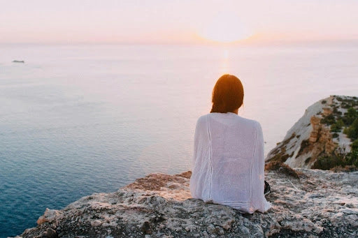woman looking at red orange sunset